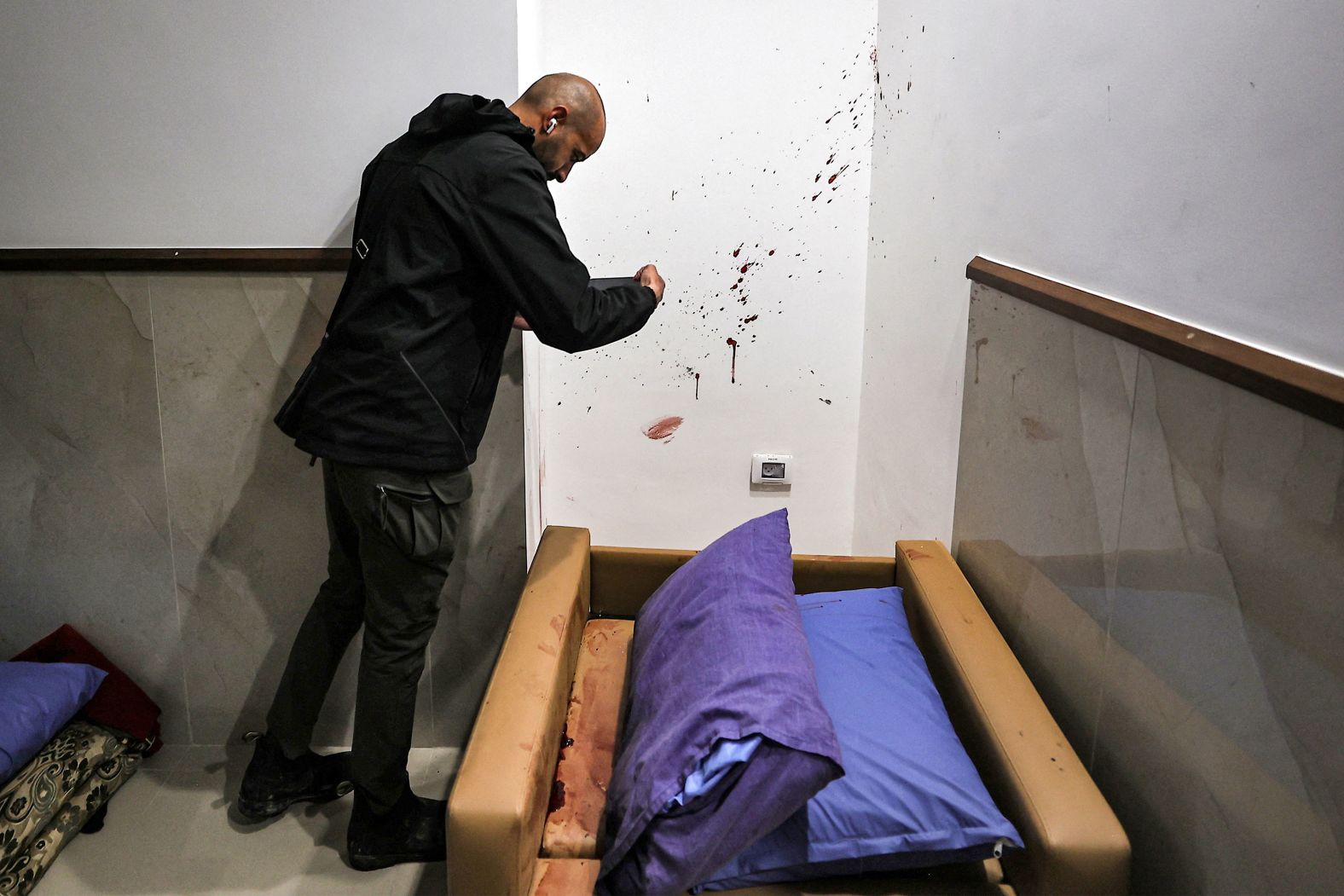 A man looks at blood splattered on a wall at the Ibn Sina hospital in the occupied West Bank city of Jenin on Tuesday, January 30. Israeli special forces, dressed as civilians and medical staff, <a href="index.php?page=&url=https%3A%2F%2Fwww.cnn.com%2F2024%2F01%2F30%2Fmiddleeast%2Fisrael-undercover-raid-jenin-west-bank-hamas-intl%2Findex.html">infiltrated the hospital and killed three Palestinian men</a>, according to Israeli and Palestinian officials. The hospital said the three men were sleeping at the time of the attack. One of those killed was claimed by Hamas as a member; the other two were claimed by Islamic Jihad, another militant group.