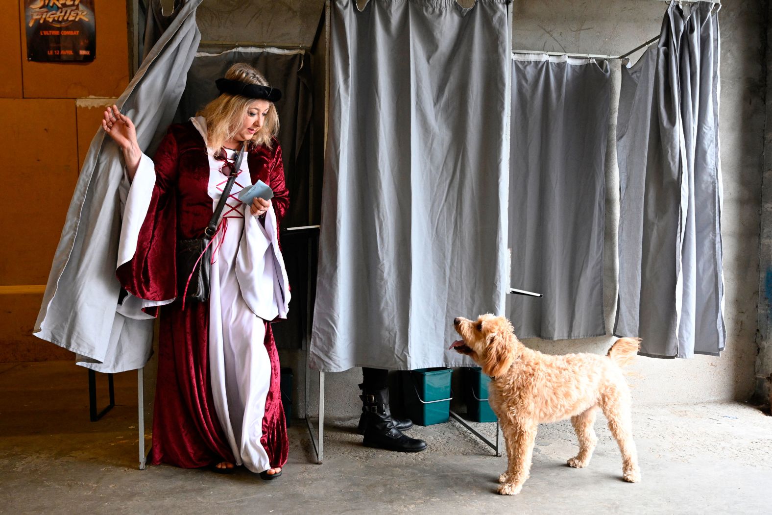A voter in a medieval costume faces a dog as she comes out of a polling booth in Rodemack, France, on Sunday, June 30. A medieval festival was taking place on the same day that voting was being held for <a href="index.php?page=&url=https%3A%2F%2Fwww.cnn.com%2F2024%2F06%2F30%2Feurope%2Fmacron-france-election-first-round-intl%2Findex.html">the country’s parliamentary elections</a>.