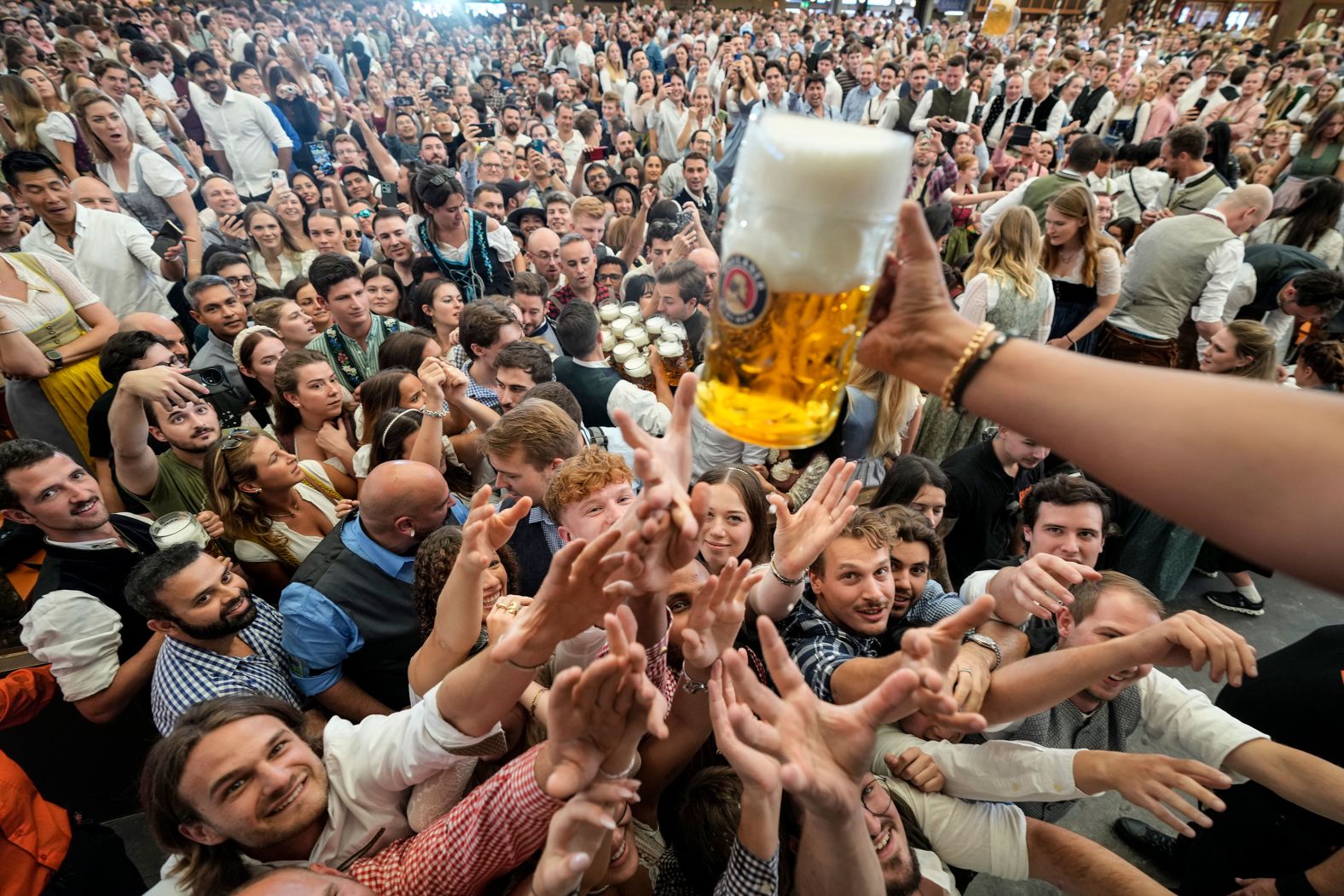 Festival goers reach for a beer on the first day of the Oktoberfest beer festival in Munich, Germany, on Saturday, September 21.