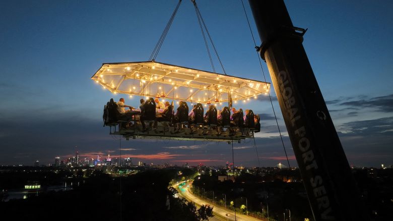 TOPSHOT - This aerial view shows customers having dinner during an event organised by Polish restaurant service of Belgian origin 'Dinner in the Sky', which uses a crane to hoist its guests, table, and waiting staff 50 meters into the air, in Warsaw on August 17, 2024. (Photo by Sergei GAPON / AFP) (Photo by SERGEI GAPON/AFP via Getty Images)