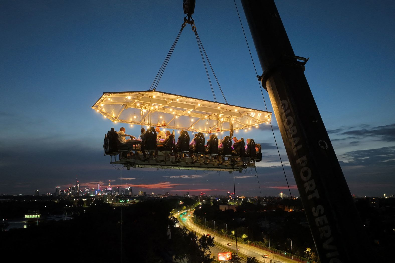 People in Warsaw, Poland, enjoy Dinner in the Sky, a special dining experience where a crane holds their dinner party in midair, on Saturday, August 17.