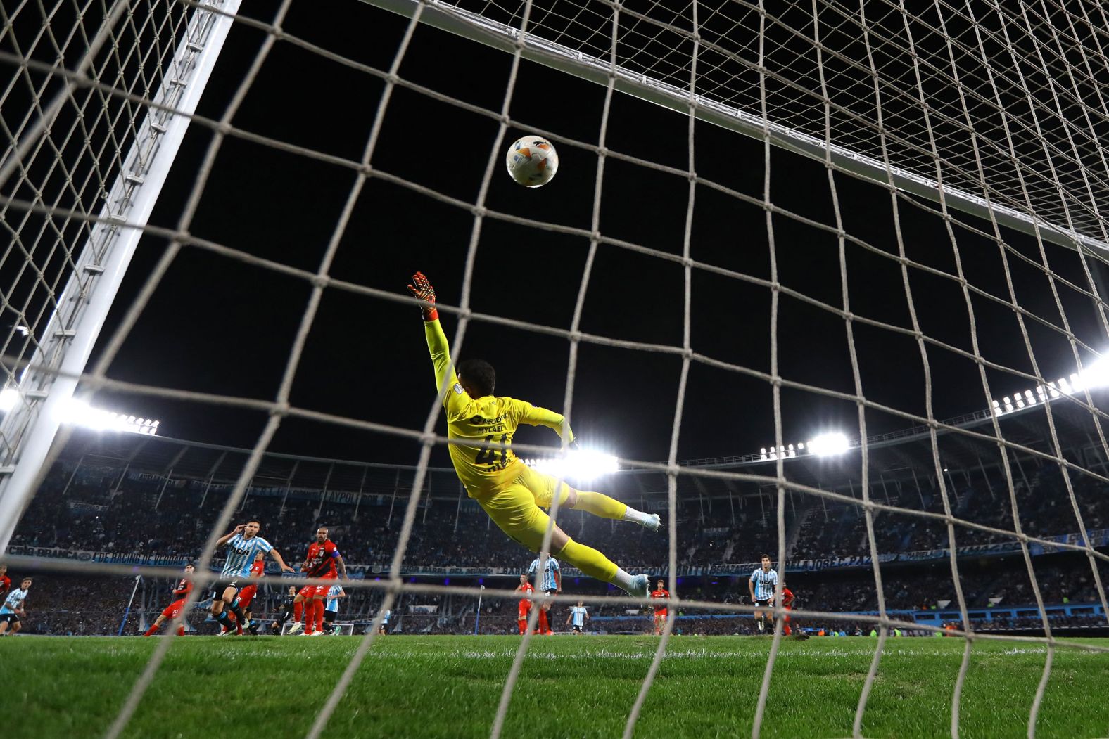 Racing’s Gastón Martirena, at center left in the blue and white stripes, scores his team’s fourth goal in a 4-1 victory over Athletico Paranaense on Thursday, September 26. With the win, the Argentine side advanced to the semifinals of the Copa Sudamericana.