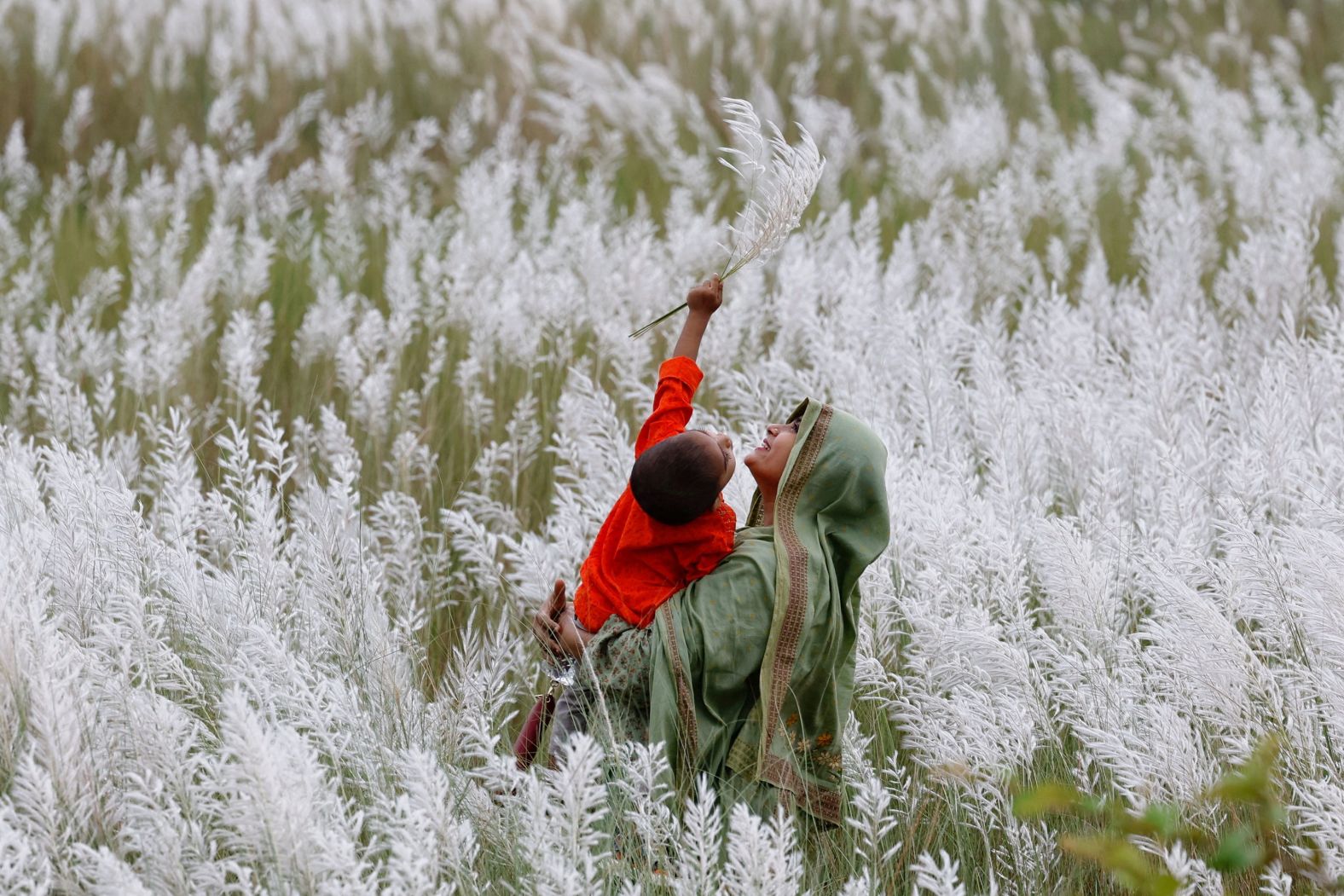 A woman holds a child in a flower field in Dhaka, Bangladesh, on Friday, September 13.