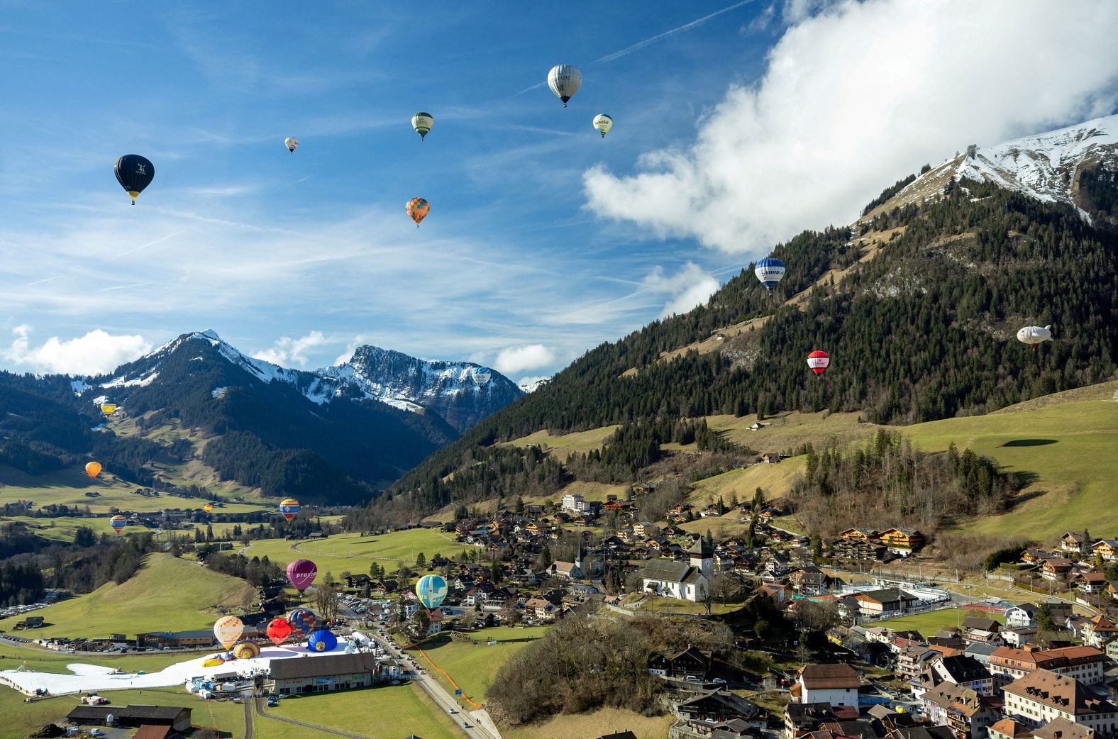 Balloons fly over Château-d'Oex, Switzerland, during the International Hot Air Balloon Festival on Thursday, January 25.