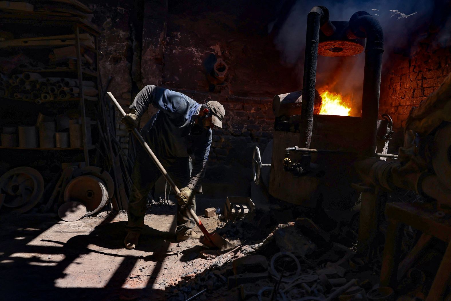 A man works near the furnace of an iron-melting workshop in the industrial district of Sheikh Omar in Baghdad on Thursday, August 15.