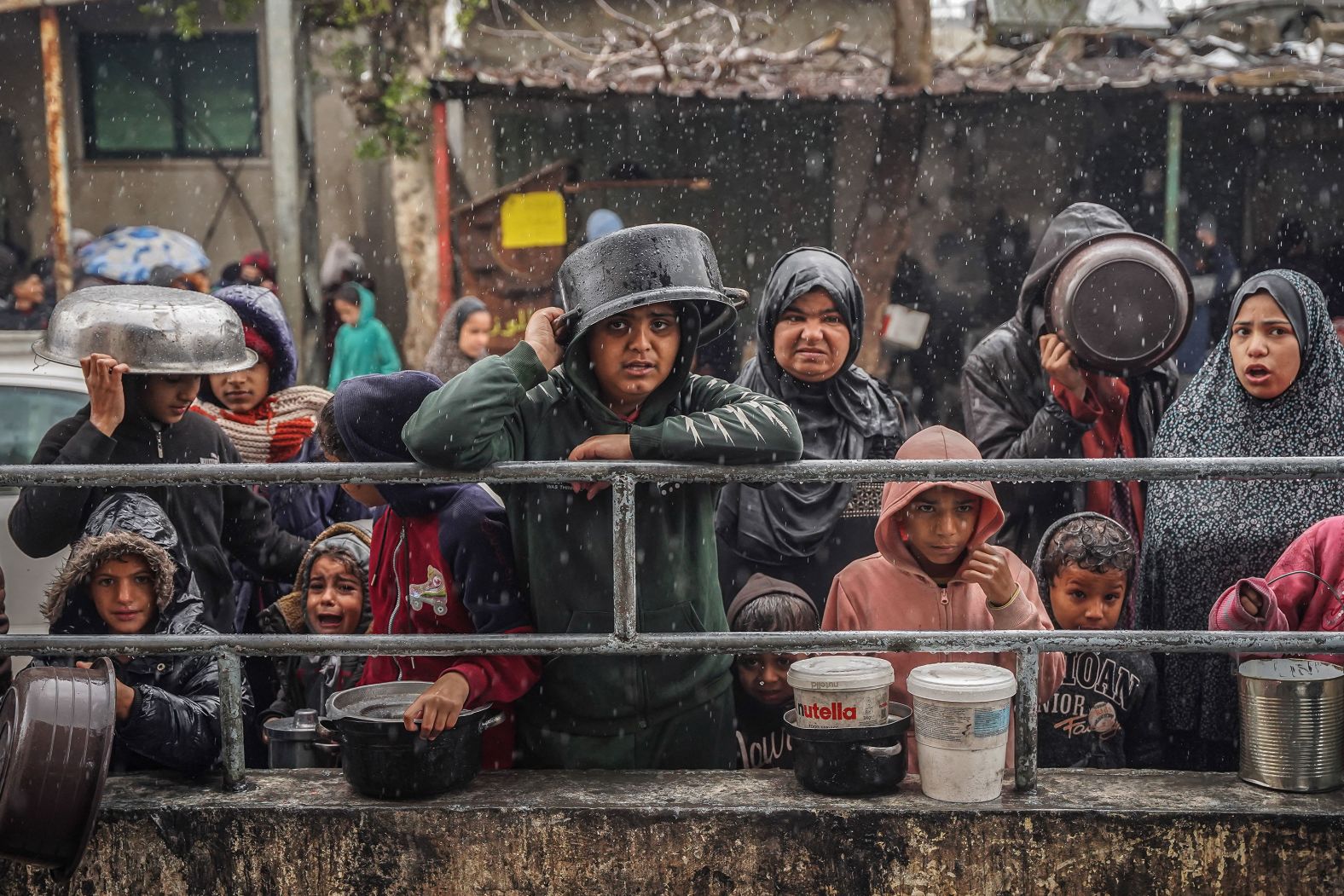 Palestinians wait to receive food at a refugee camp in Rafah, Gaza, on Saturday, January 27. According to the UN's Office for the Coordination of Humanitarian Affairs, at least 1.7 million people in Gaza <a href="index.php?page=&url=https%3A%2F%2Fwww.cnn.com%2F2024%2F01%2F25%2Fmiddleeast%2Ftorrential-rain-gaza-israel-khan-younis-offensive-intl%2Findex.html">have been internally displaced</a> since Israel launched its offensive there to eliminate the Hamas militant group.