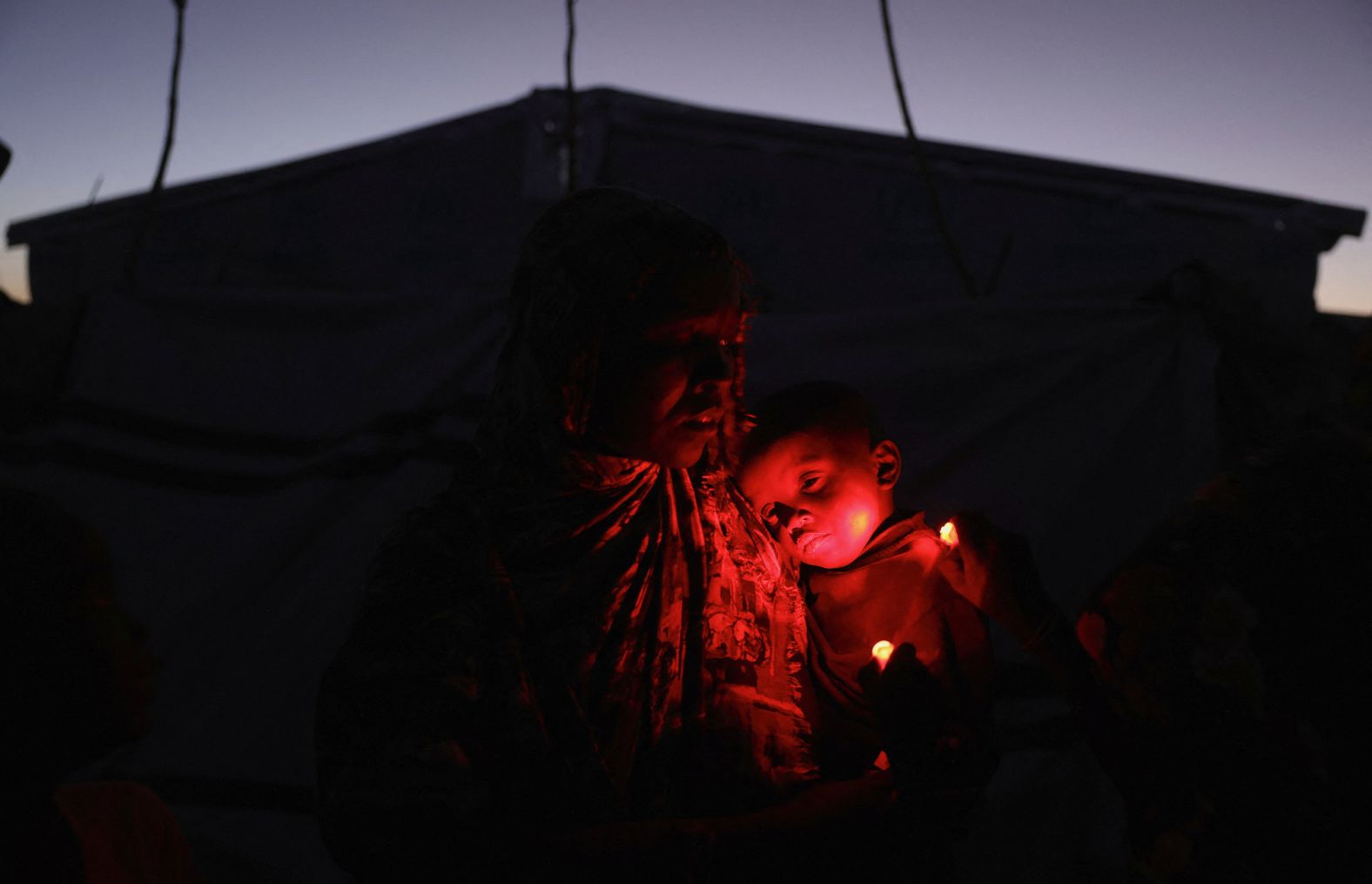 A woman from Sudan carries her sick child at a refugee camp in eastern Chad on Friday, November 21.<a  href="/mt/?noimg=&dark=on&url=https%3a%2f%2fwww.cnn.com%2finteractive%2f2025%2f05%2fworld%2fsudan-civil-war-cnnphotos%2f">Sudan’s civil war</a> has forced millions to flee their homes.