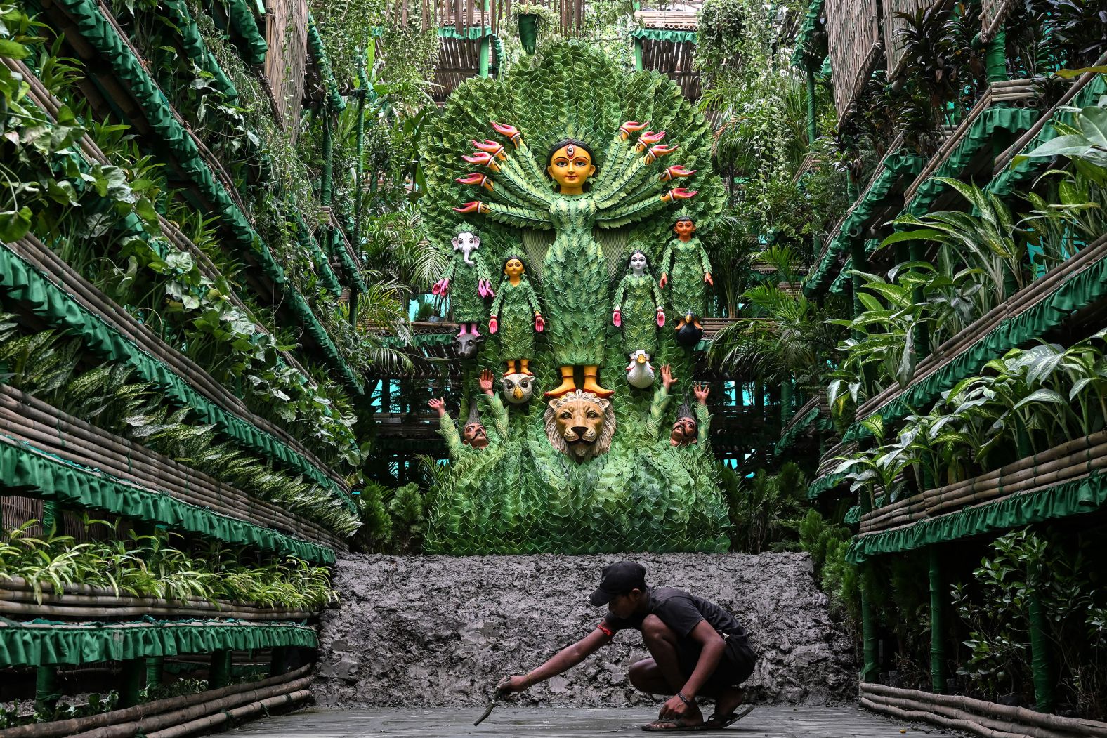 An artisan puts the finishing touches to a pandal during the Durga Puja festival in Kolkata, India, on Saturday, October 5. More than 8,000 natural plants surround an idol of the Hindu goddess Durga.