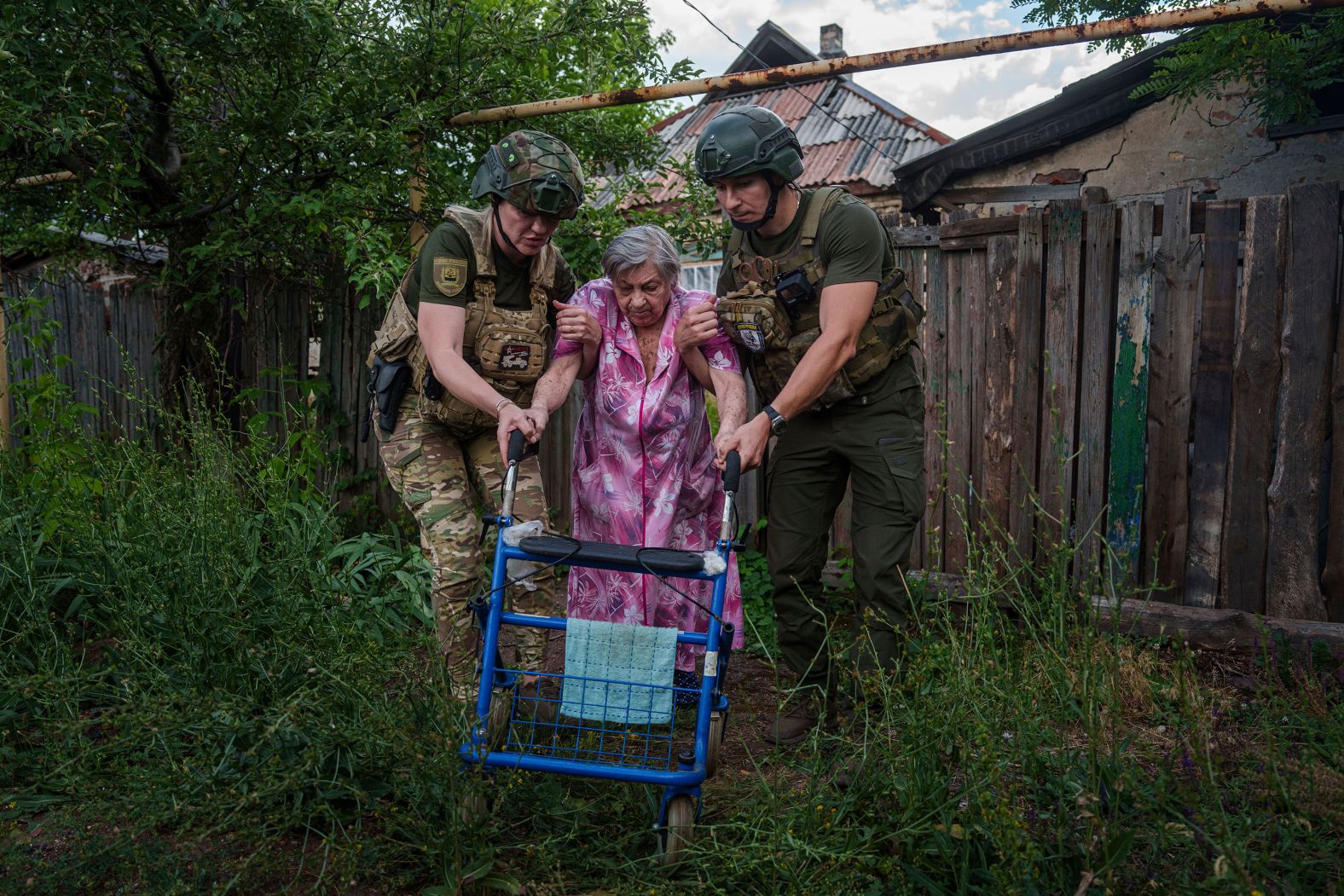 Police officers in Toretsk, Ukraine, help a woman evacuate her home in the war-torn Donetsk region on Friday, June 28.