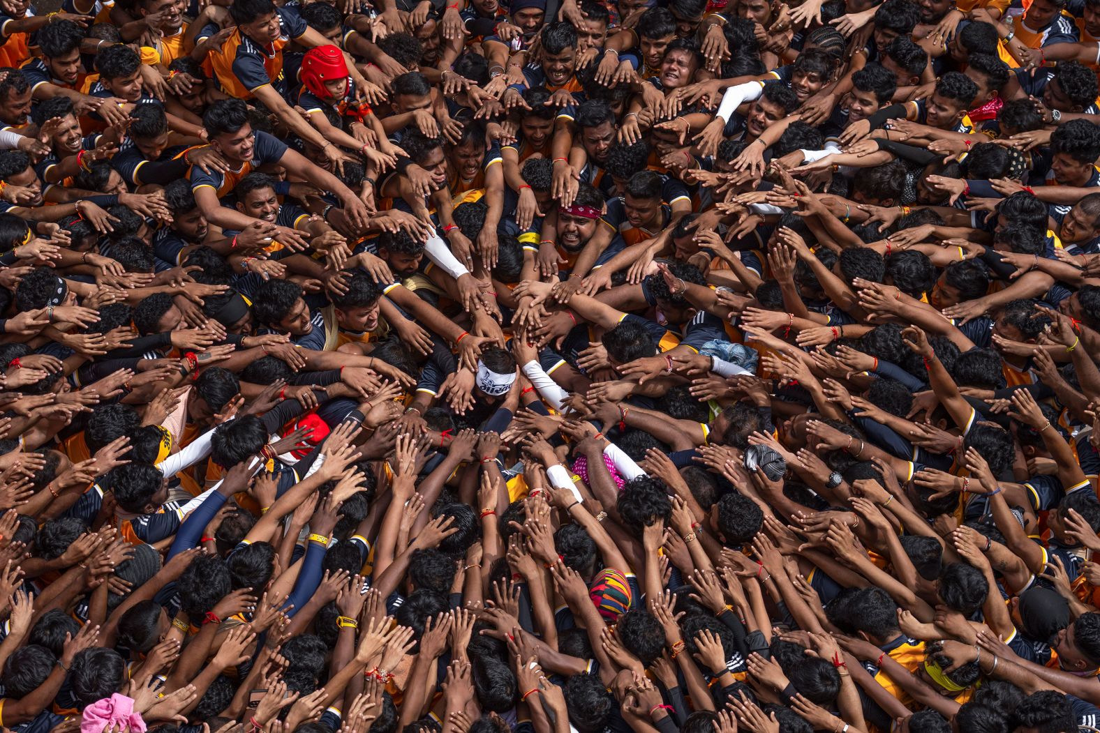 People in Mumbai, India, pay respect before forming human pyramids to reach an overhanging earthen pot during Janmashtami, the festival that marks the birth of the Hindu god Krishna, on Tuesday, August 27.