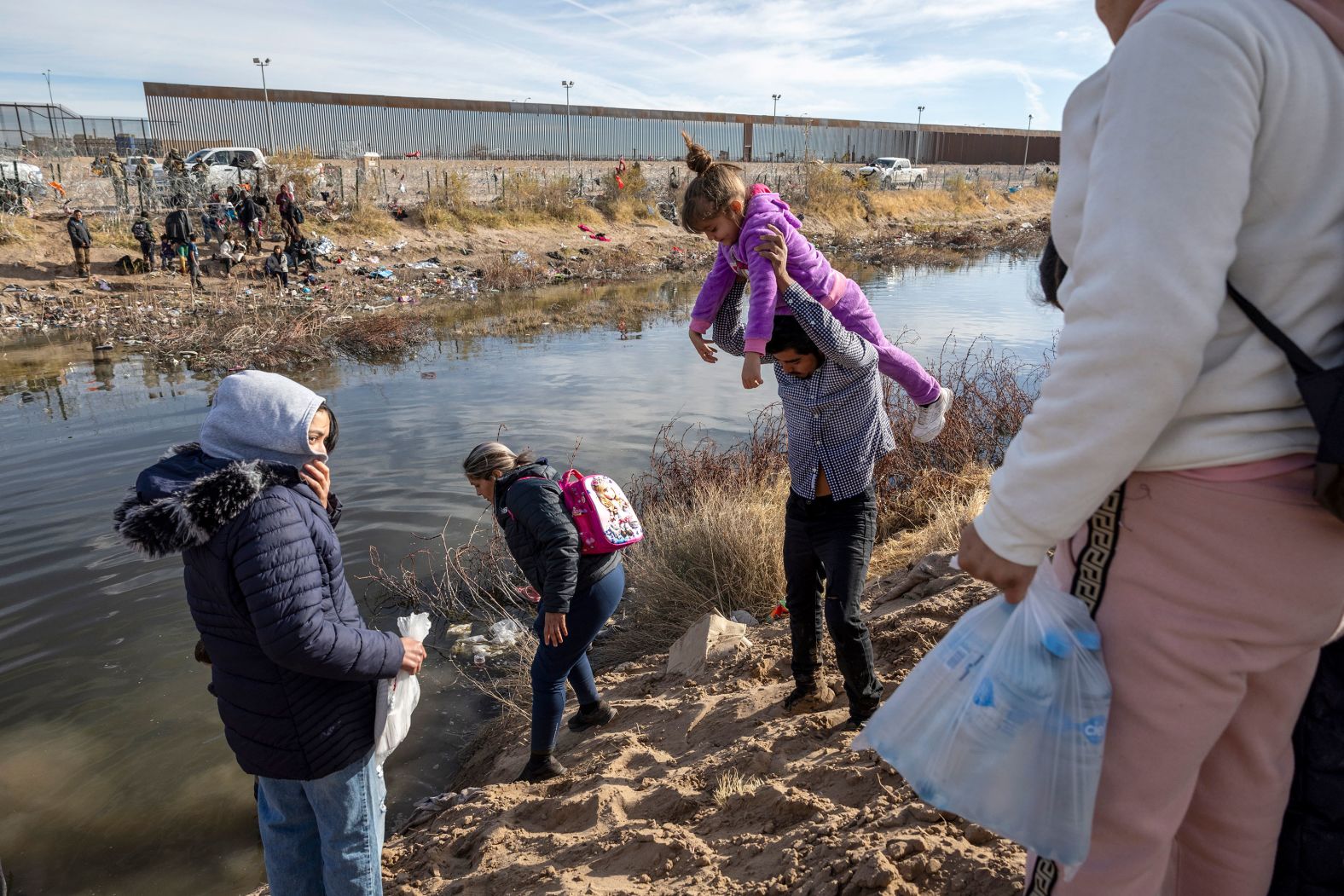 Migrants prepare to wade across the Rio Grande, from Ciudad Juarez, Mexico, to El Paso, Texas, on Tuesday, January 30. <a href="index.php?page=&url=https%3A%2F%2Fwww.cnn.com%2F2024%2F01%2F23%2Fus%2Fus-mexico-border-texas-migrants%2Findex.html">There is an ongoing legal dispute</a>, between the Biden administration and Texas, over whether federal agents have the legal authority to cut razor wire that Texas installed on the banks of the Rio Grande. The Supreme Court recently voted 5-4 to allow wire-cutting while the legal challenge plays out.