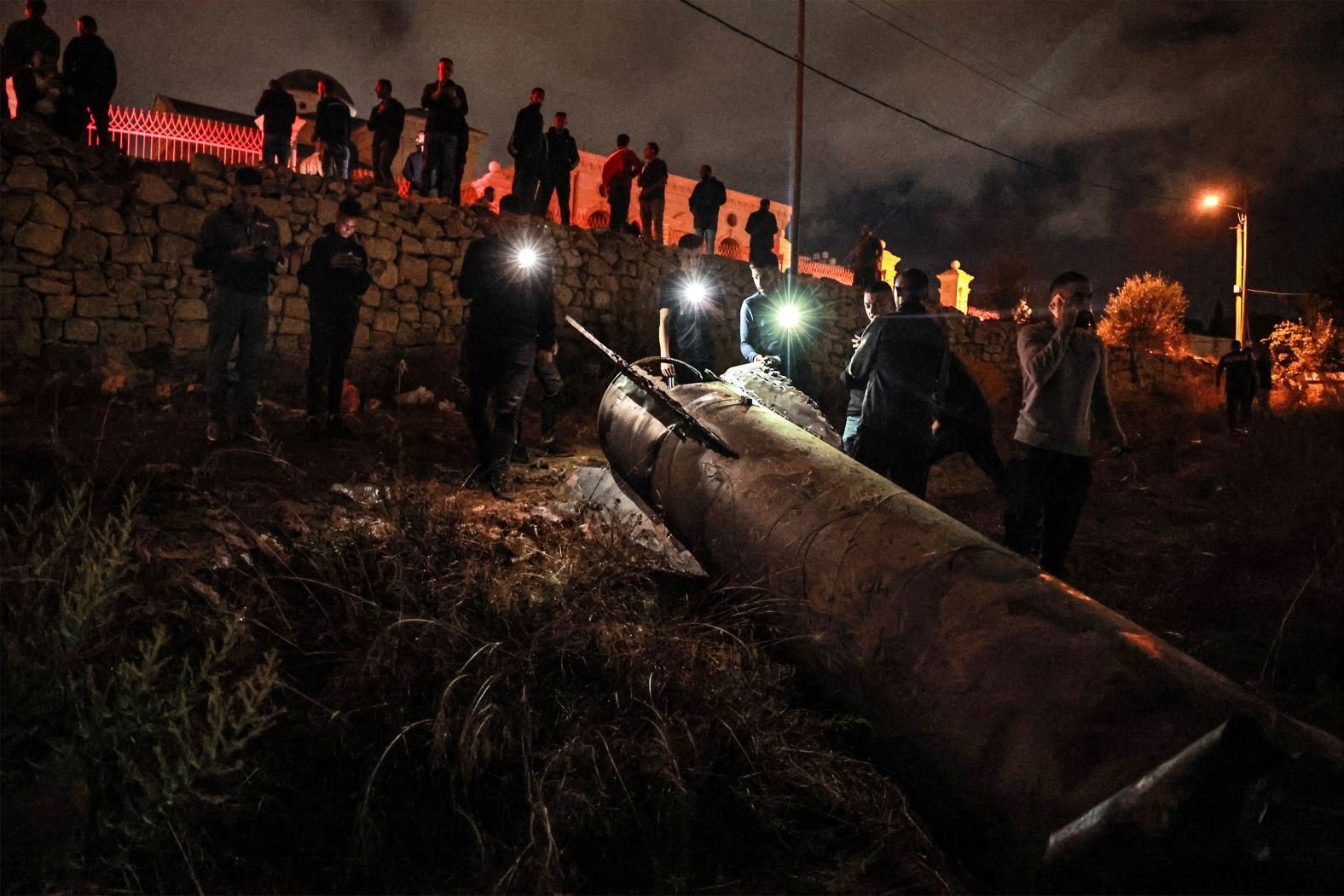 Young Palestinians in Ramallah, West Bank, inspect a fallen projectile on Tuesday, October 1, after <a href="index.php?page=&url=https%3A%2F%2Fwww.cnn.com%2F2024%2F10%2F01%2Fpolitics%2Firan-missile-attack-israel%2Findex.html">Iran launched a barrage of missiles at Israel</a> in response to the killings of Hezbollah leader Hassan Nasrallah and other Iran-backed militants. The Israel Defense Forces said it intercepted many of the missiles, but some landed on the ground in Israel and the occupied West Bank.
