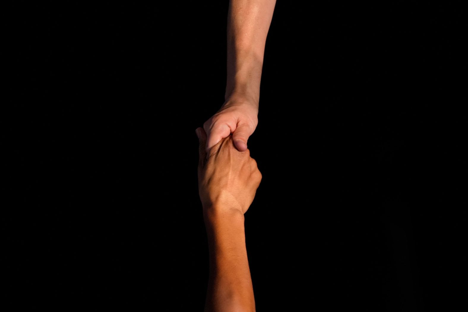 Former President Barack Obama holds the hand of an audience member during a campaign rally in Detroit for Vice President Kamala Harris on Tuesday, October 22.