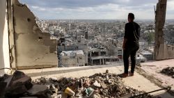 TOPSHOT - A man standing atop a heavily damaged building views other destroyed buildings in Khan Yunis in the southern Gaza Strip on October 7, 2024 on the first anniversary of the ongoing war in the Palestinian territory between Israel and Hamas. (Photo by Bashar TALEB / AFP) (Photo by BASHAR TALEB/AFP via Getty Images)