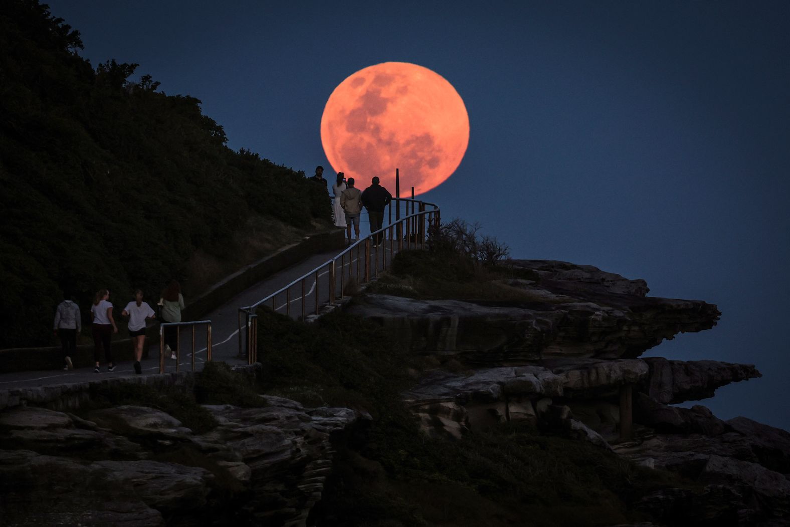 A full moon rises in front of people near Sydney’s Bondi Beach on Thursday, October 17. <a href="https://www.cnn.com/2024/10/17/science/gallery/october-2024-hunters-moon/index.html">See more photos of the October hunter’s moon</a>.