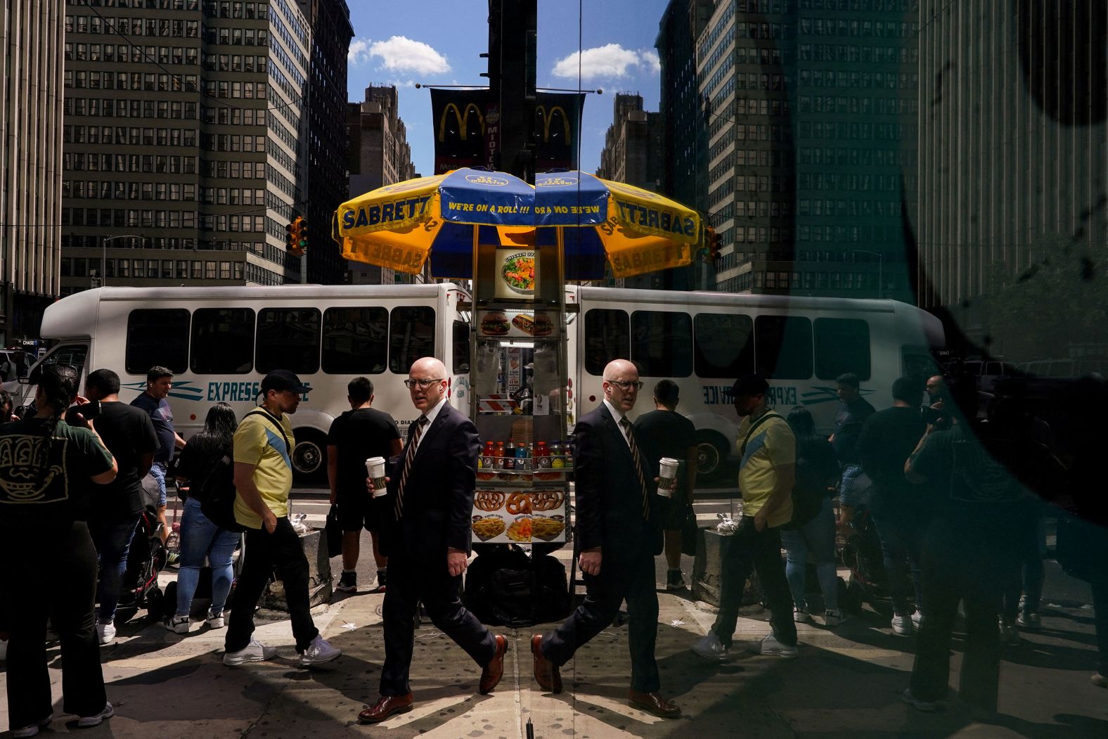 People are reflected during a hot day in New York City on Thursday, June 27.