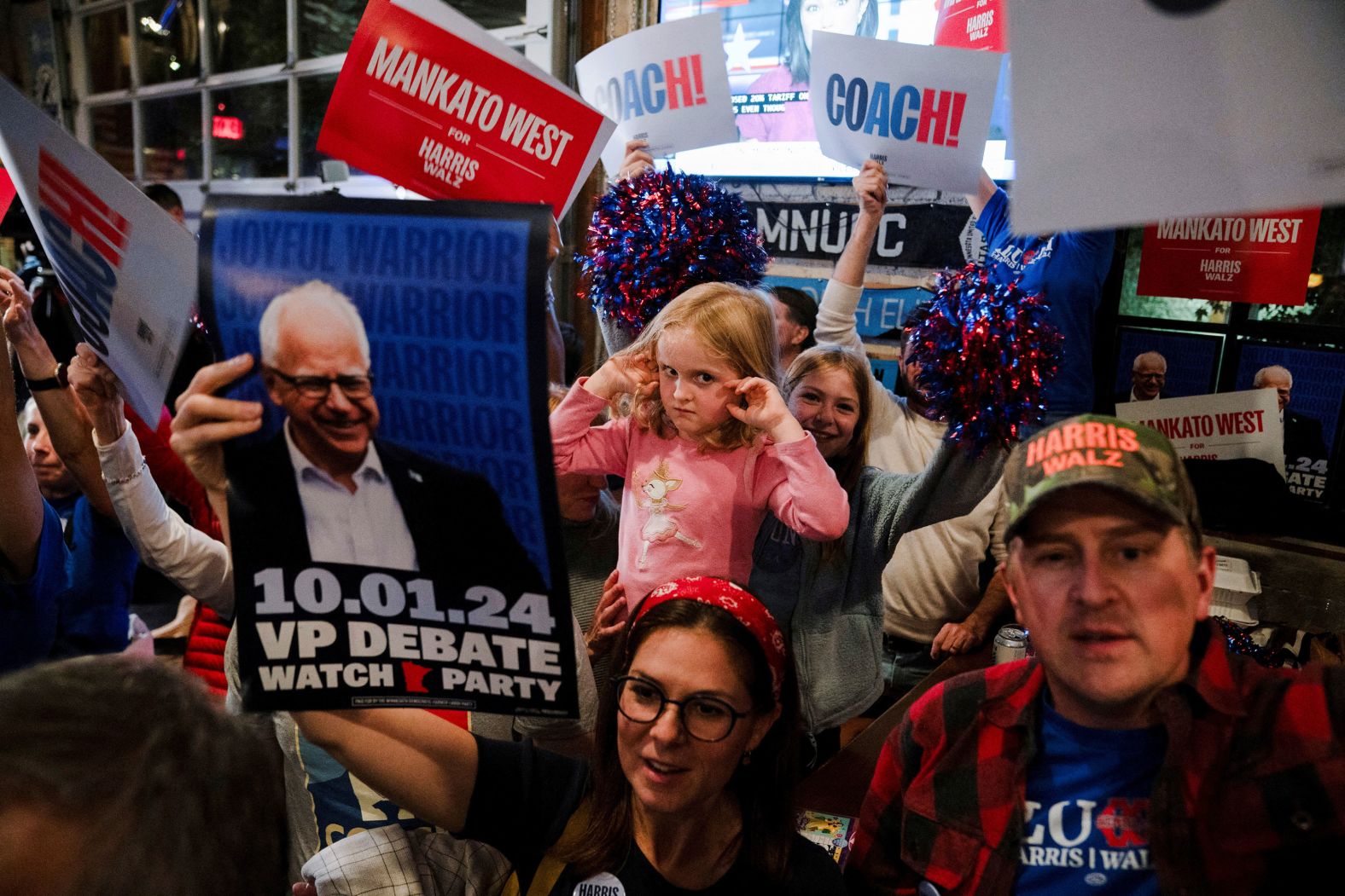 Margaret Jagdfeld, 4, covers her ears as alumni of Mankato West High School, where vice presidential candidate Tim Walz formerly taught, cheer for Walz at a debate watch party in St. Paul, Minnesota, on Tuesday, October 1.