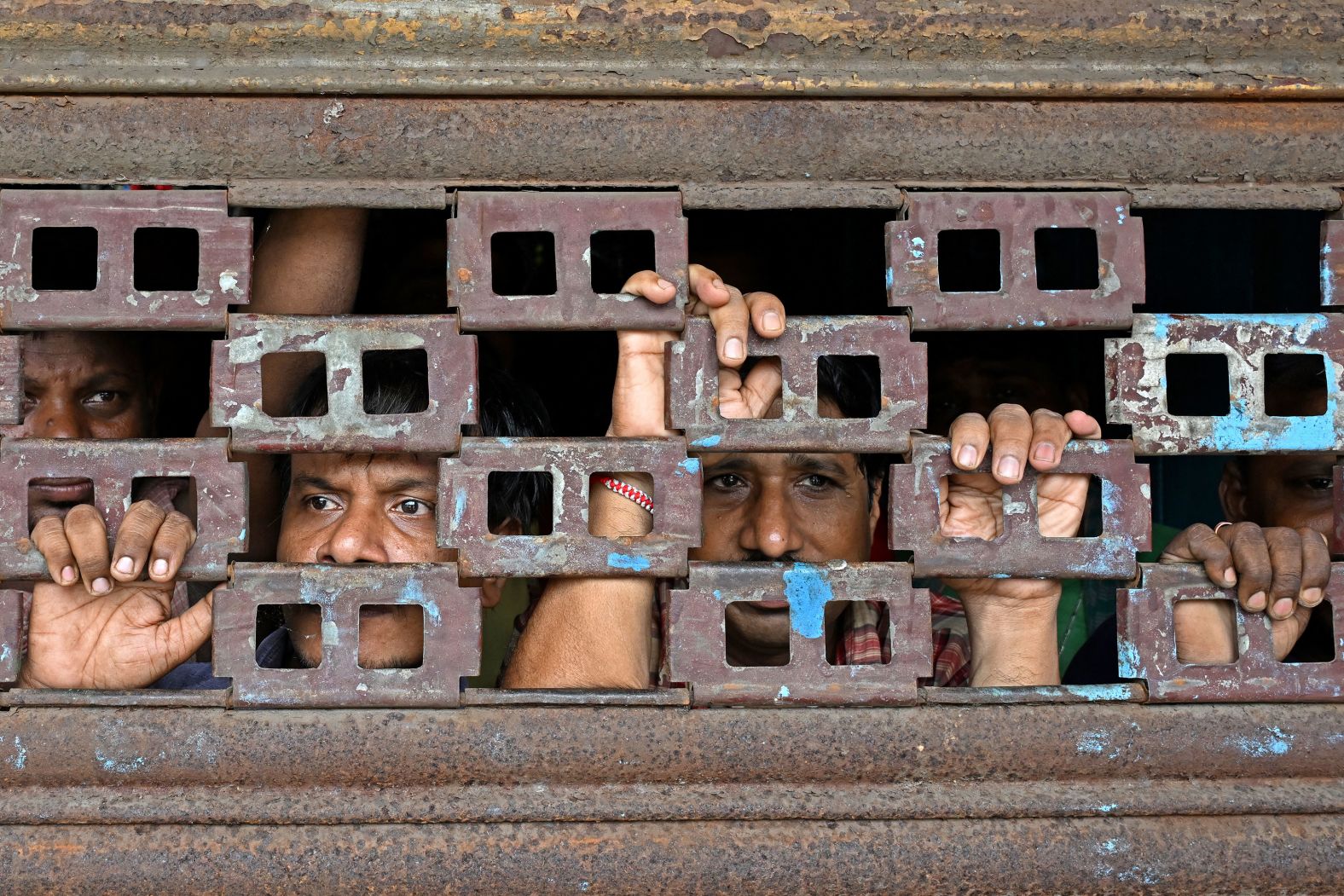 People look out from a closed shop in Kolkata, India, as activists march toward the state secretariat and demand the resignation of Mamata Banerjee, chief minister of India's West Bengal state, on Tuesday, August 27. Earlier this month, <a >thousands of doctors?went on strike across India</a> to demand better protection for health workers after a trainee medic was raped and murdered?in eastern West Bengal.