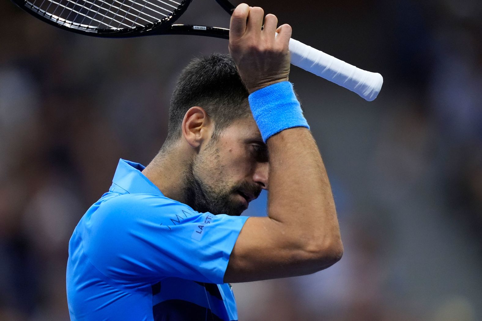 Novak Djokovic wipes his face during his third round match against Alexei Popyrin at the US Open in Flushing, New York, on Friday, August 30. Djokovic suffered a stunning upset to the No. 28 seed Australian, losing the match 6-4, 6-4, 2-6, 6-4.