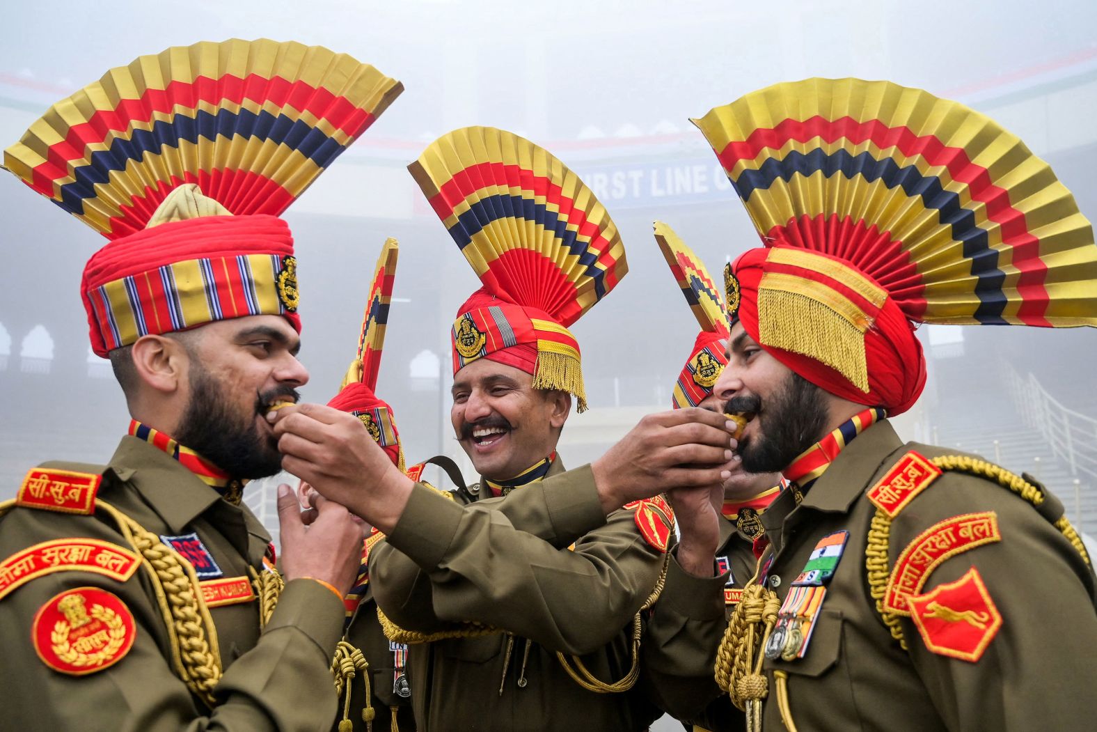 Soldiers with the Indian Border Security Force offer sweets to one another as they celebrate the country’s Republic Day at a post near the Pakistani border on Friday, January 26.