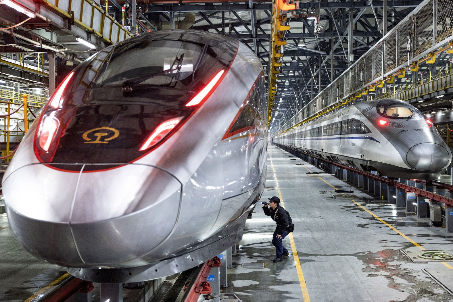 A worker inspects a high-speed train at a maintenance base in Wuhan, China, on Friday, January 26. Preparations are being made ahead of Lunar New Year travel.