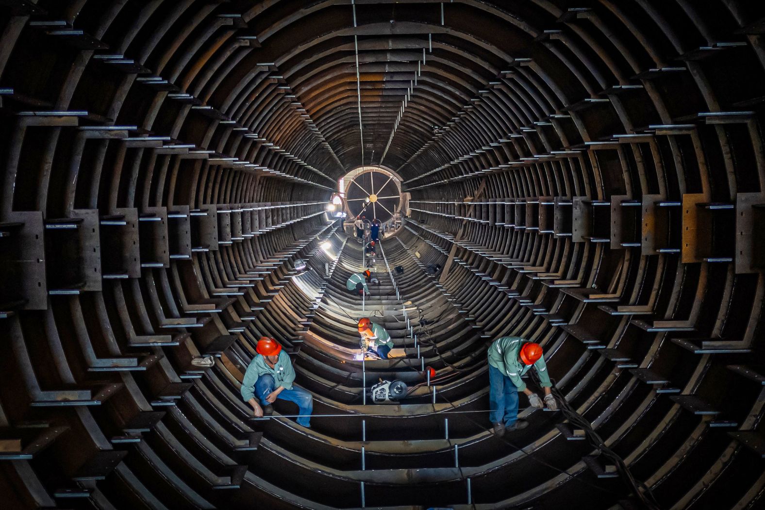Employees work on a steel tube tower production line at a factory in Haian, China, on Sunday, September 1.