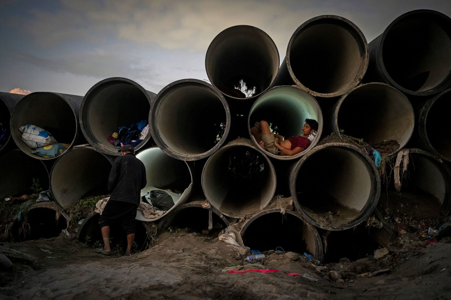A man sits inside a concrete pipe meant for municipal use after his shelter was swept away by <a href="index.php?page=&url=https%3A%2F%2Fwww.cnn.com%2F2024%2F09%2F30%2Fasia%2Fnepal-floods-kathmandu-climate-intl-hnk%2Findex.html">flooding</a> in Kathmandu, Nepal, on Tuesday, October 1.