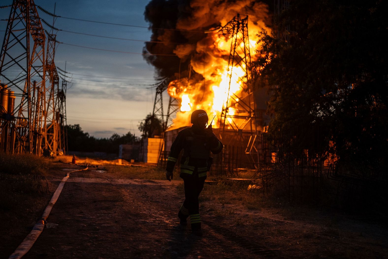 A Ukrainian firefighter talks on a radio while working to extinguish a fire at an electrical substation that was hit by a Russian strike in Ukraine’s Dnipropetrovsk region on Monday, September 2.