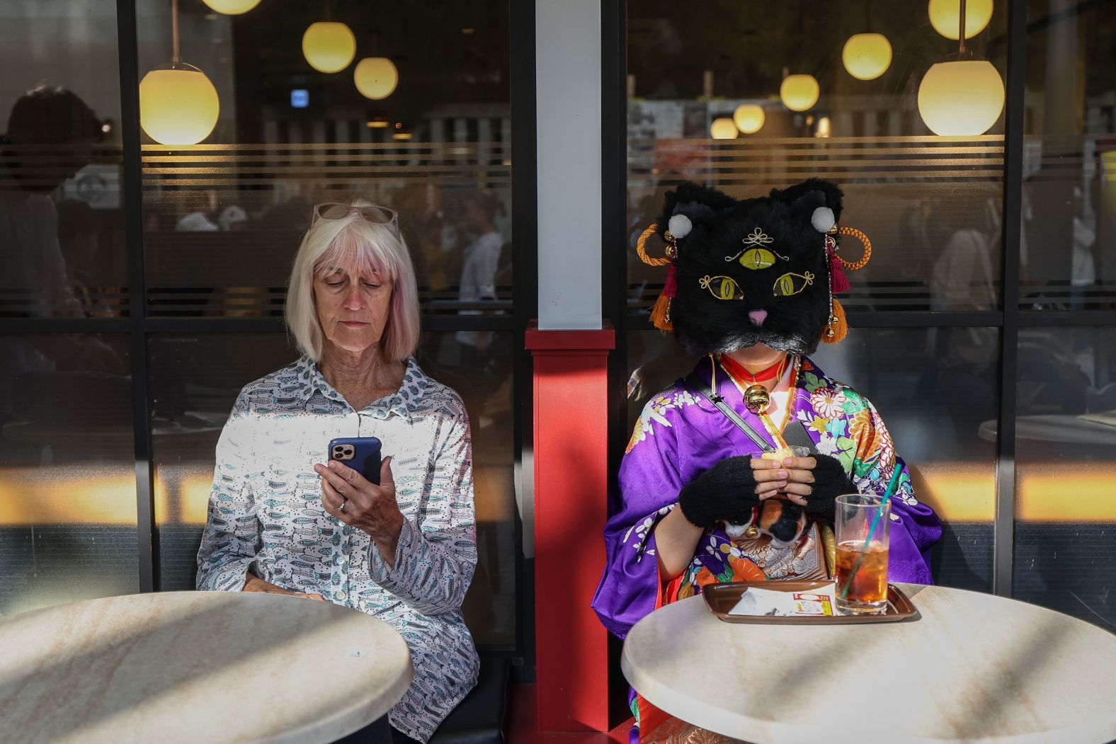 People sit at a Tokyo cafe during the Kagurazaka Bakeneko Festival on Sunday, October 13. The annual festival invites participants to embrace their feline side by dressing up as cats and showcasing their playful spirit.