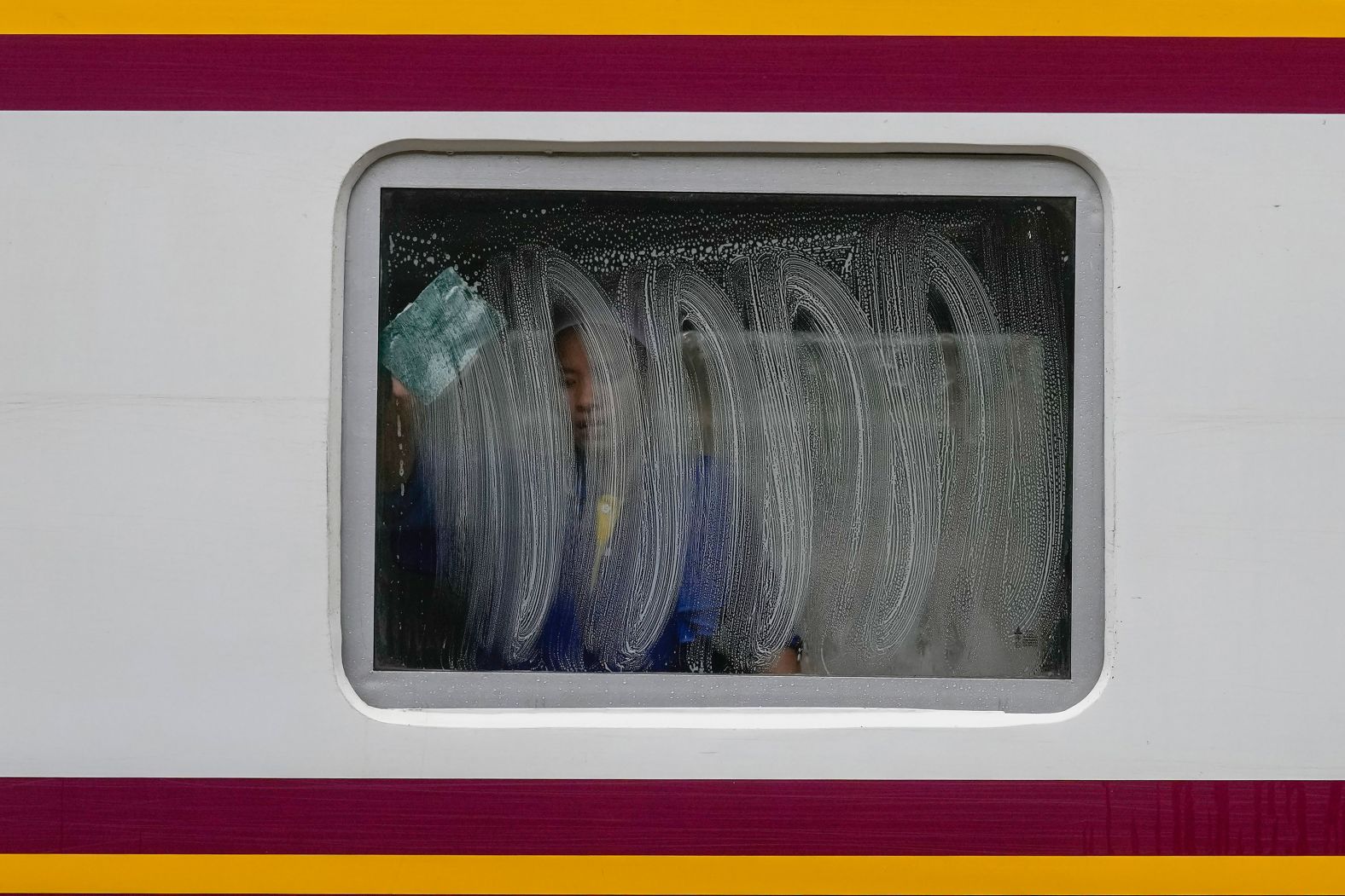 A worker cleans a window of a train at the Hua Lamphong Railway Station in Bangkok, Thailand, on Thursday, June 27.