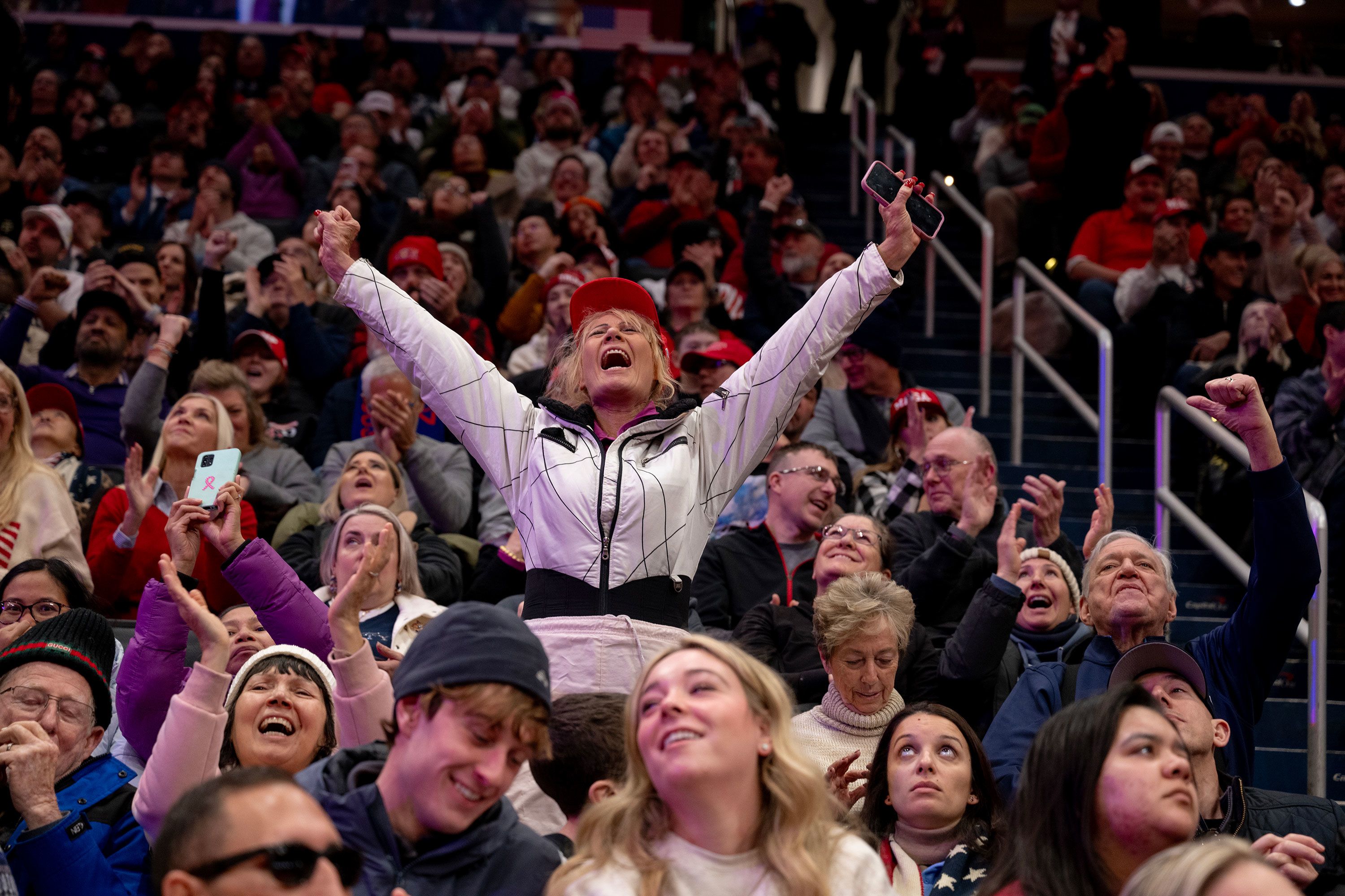 A supporter cheers while watching the inauguration from Capital One Arena.