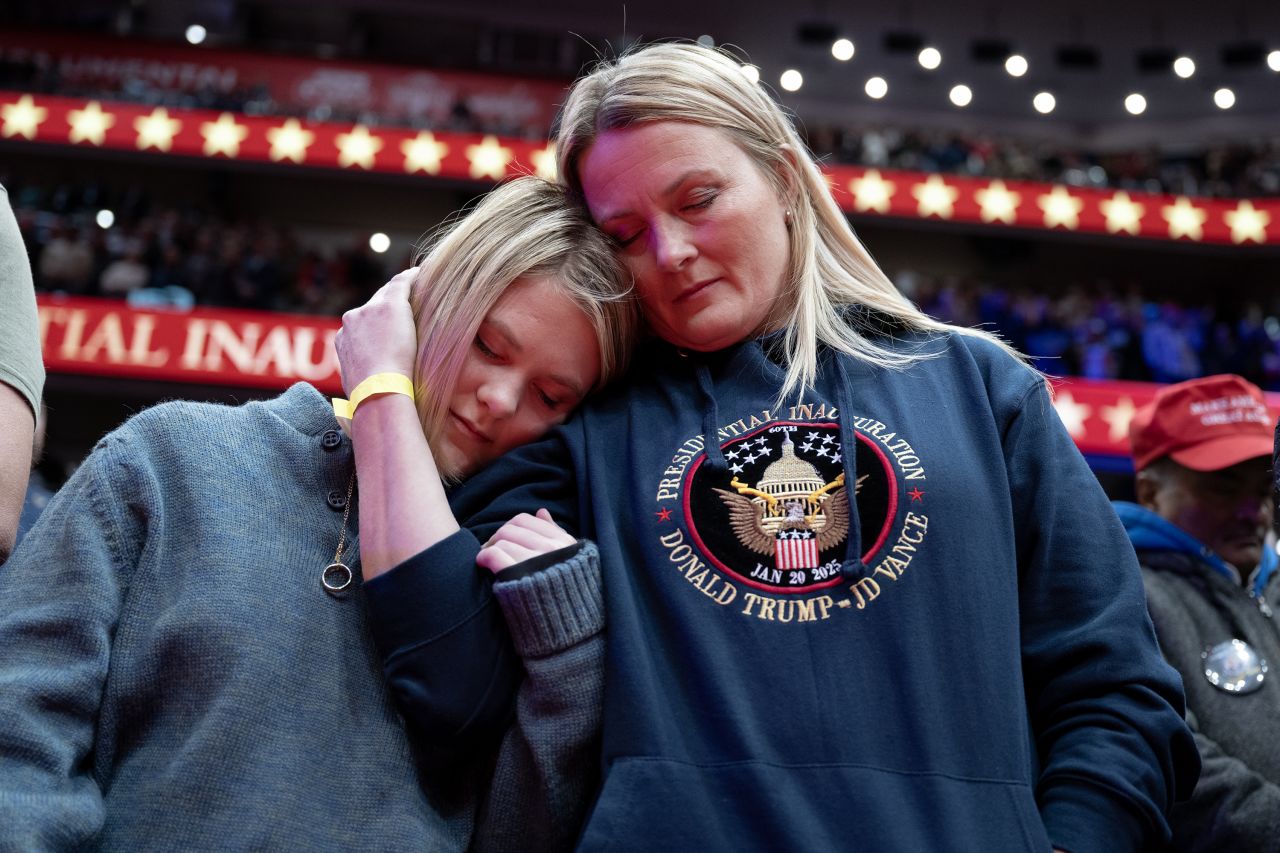 People pray inside Capital One Arena during Trump's inauguration ceremony on Monday.