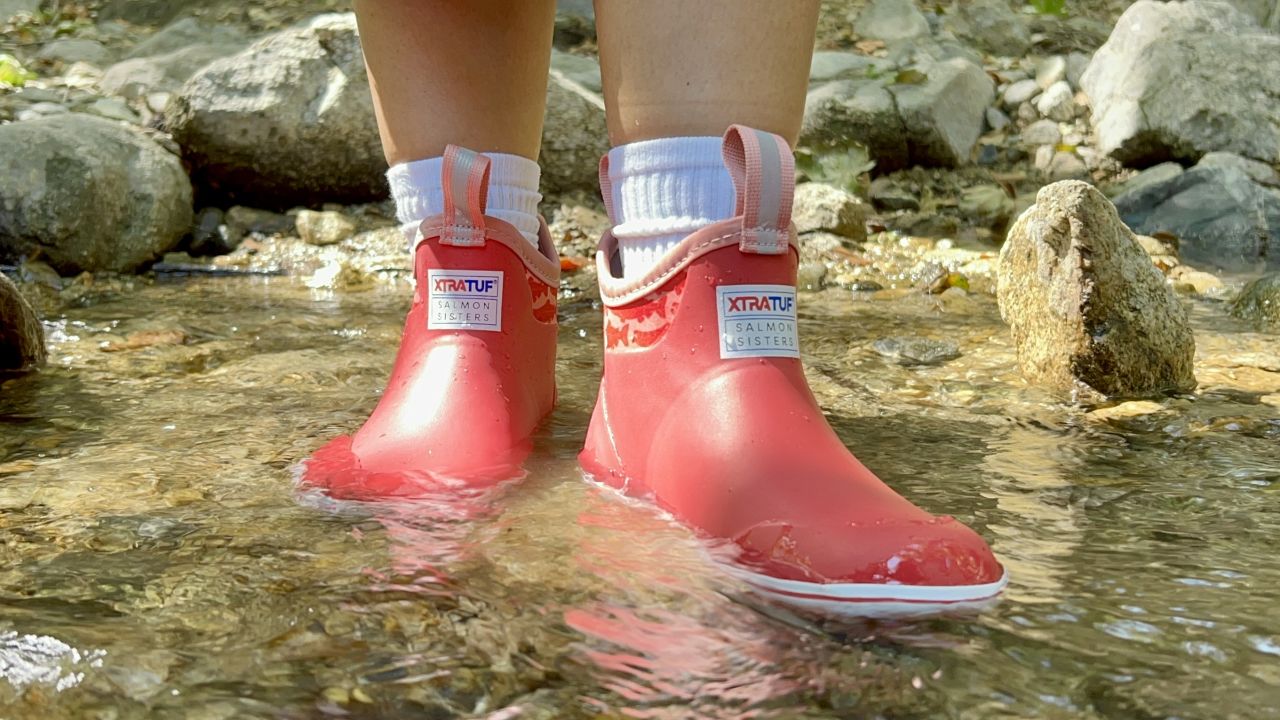 Close up of ankle rain boots worn in a river.