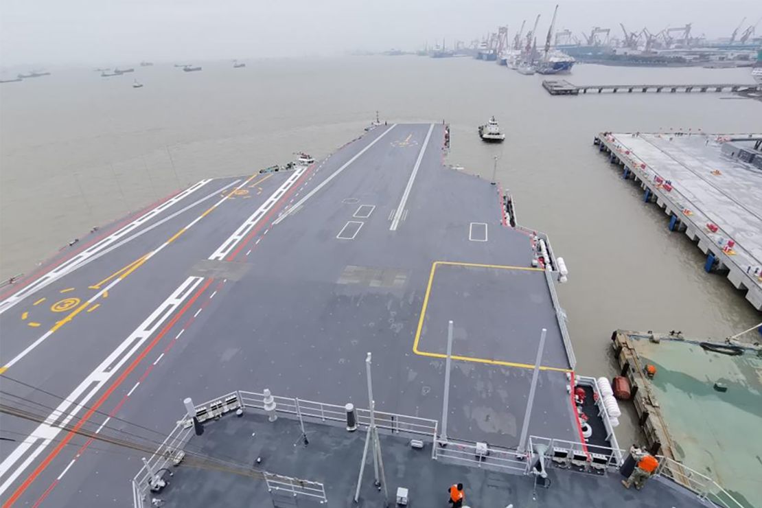 A tugboat tows China's third aircraft carrier, the Fujian, away from a dock in east China's Shanghai on May 1, 2024.