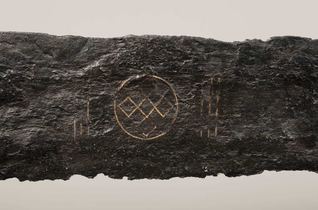 The sword features copper inlays in the shape of spiritual symbols.